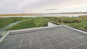Eine Terrasse mit Blick auf einen See und ferne Hügel.