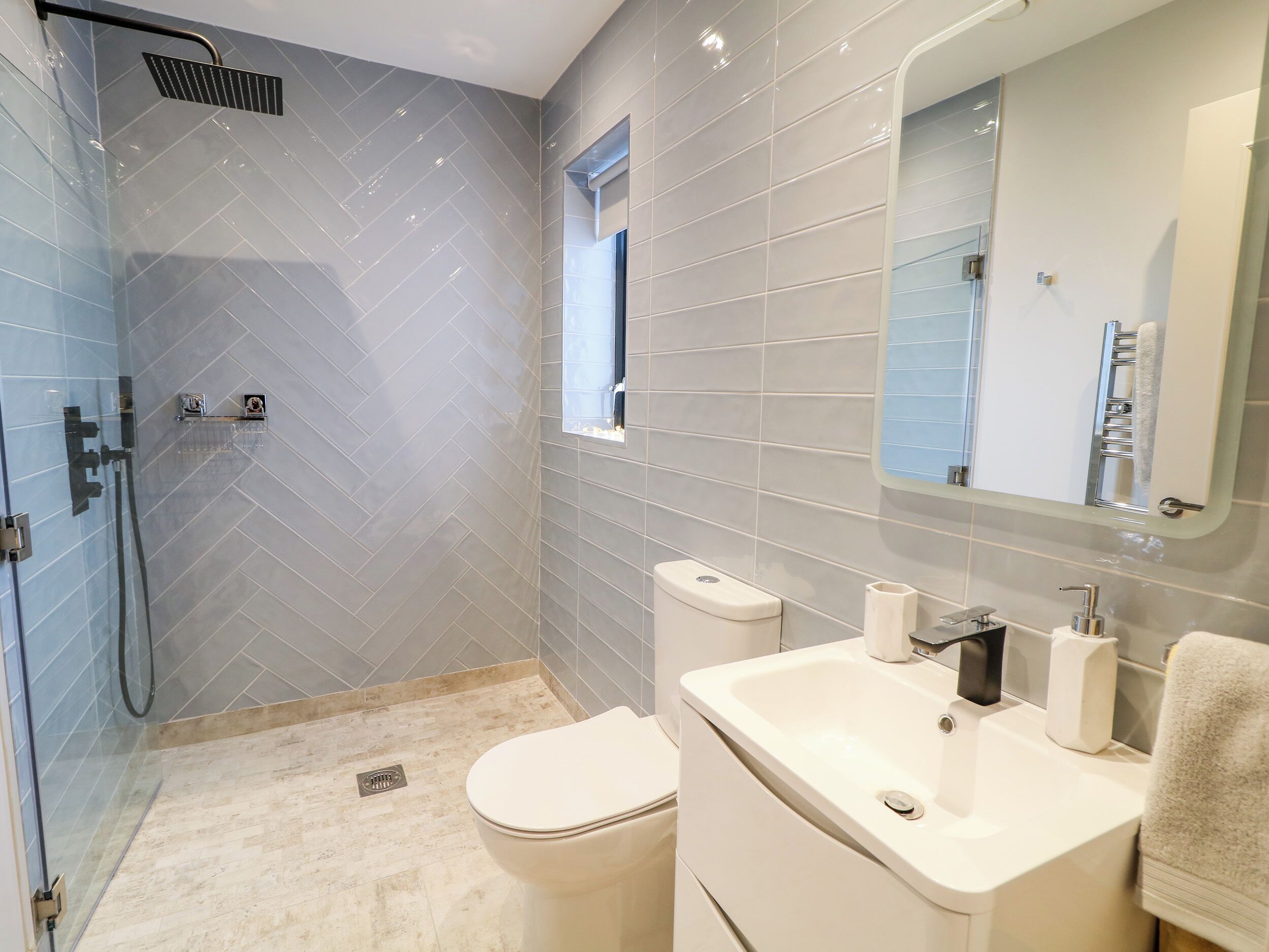 Un baño moderno con ducha, inodoro y lavabo.