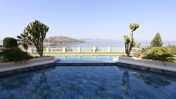 Une piscine avec vue sur la mer et les montagnes.