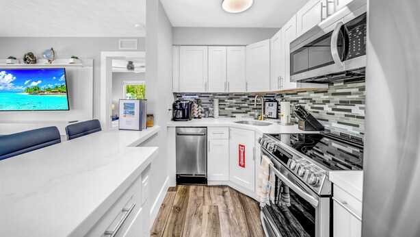 A modern kitchen with white cabinets, a built-in microwave, a stove, and a dishwasher. - Victoria Park Gem! 1 Mile To Beach & Las Olas! (Fort Lauderdale)