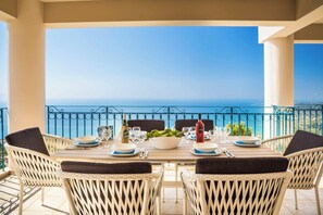 Mesa de jantar posta para quatro com vista para o mar.