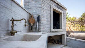 A bathroom with a marble sink, a wooden cutting board, and a window opening to a garden. - Beautiful 1-bed Apartment in Pobrezje-dubrovnik (Dubrovnik)