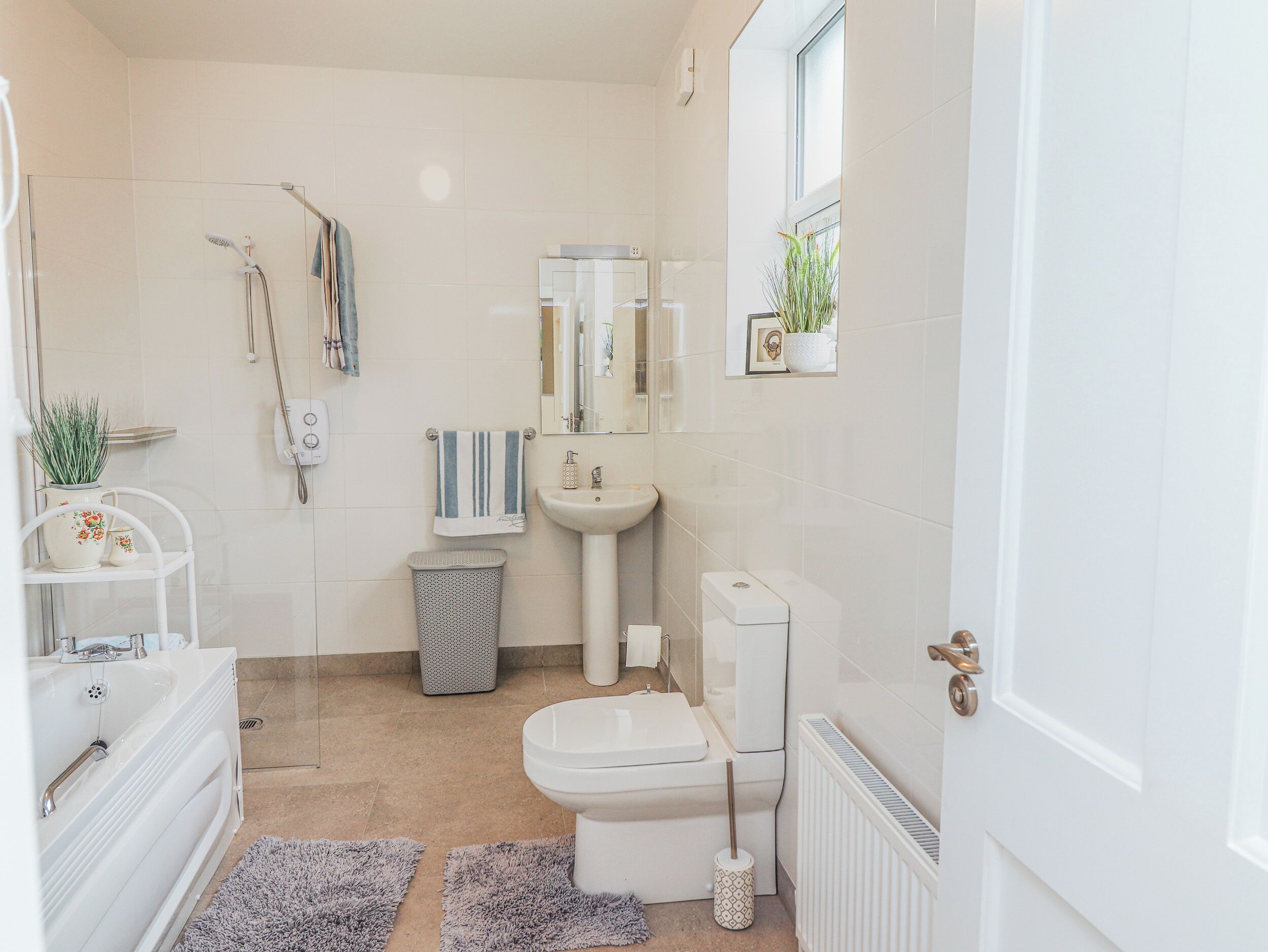 A modern bathroom with a bathtub, toilet, sink, and shower.