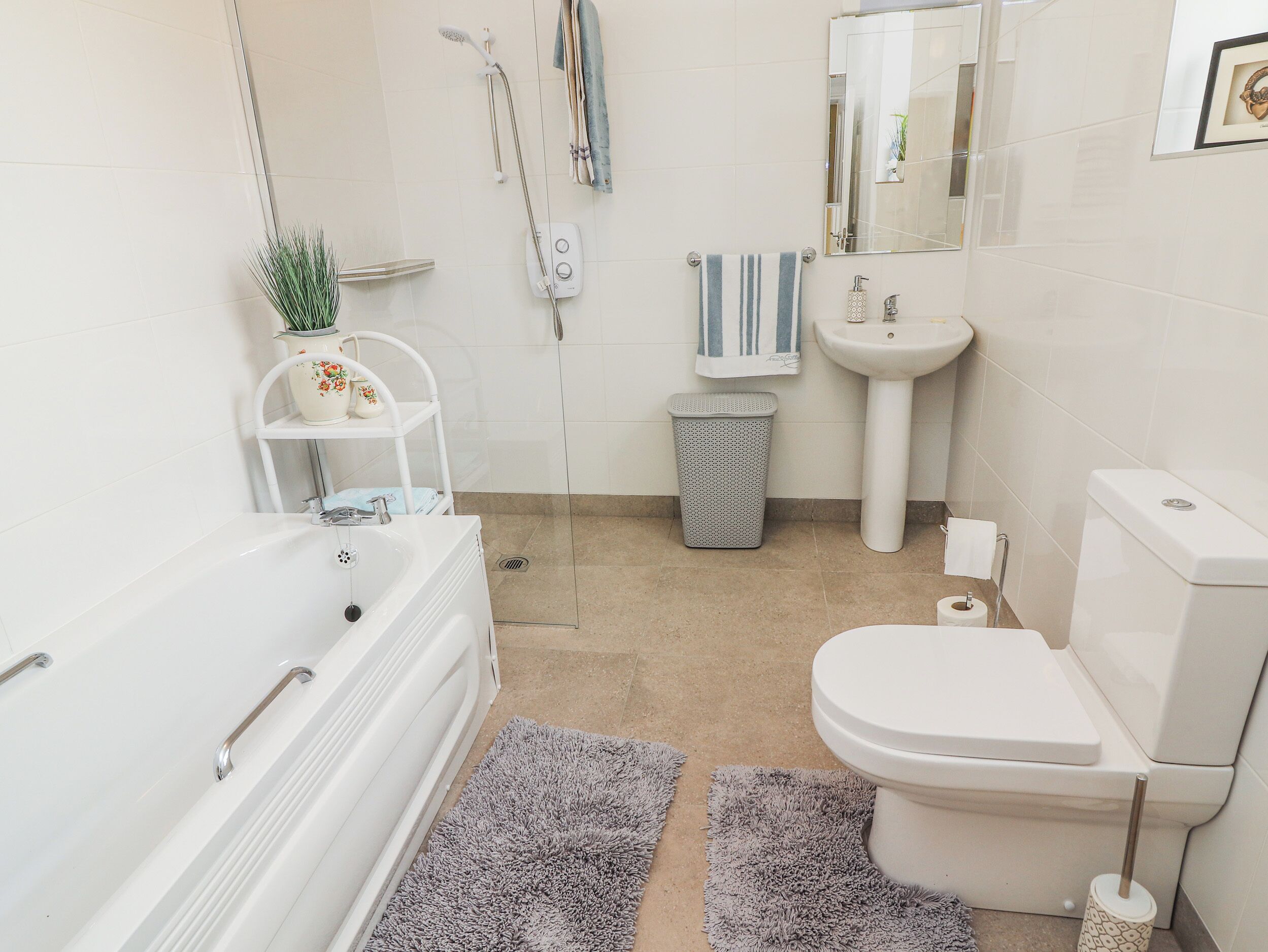 Une salle de bain moderne équipée d’une baignoire, de toilettes, d’un lavabo et d’une douche.