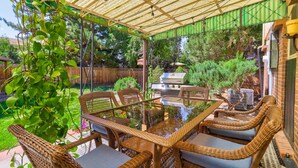 An outdoor patio with wicker furniture, a glass table, and a grill. - Large home inArvada, centrally located, 20min to downtown, garage parking, 420ok (Arvada)