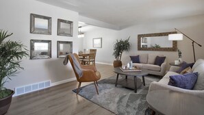 A modern living room with a sofa, armchair, coffee table, and a dining area with chairs and a table. - Large home inArvada, centrally located, 20min to downtown, garage parking, 420ok (Arvada)