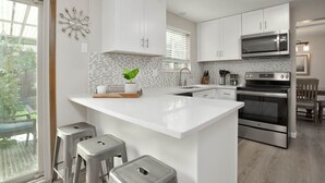 A modern kitchen with white cabinetry, a large island, stainless steel appliances, and a view of the outdoors. - Large home inArvada, centrally located, 20min to downtown, garage parking, 420ok (Arvada)