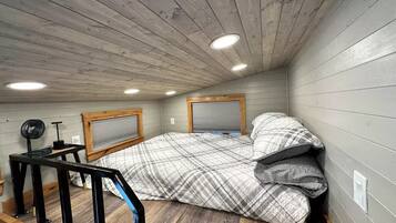 Una habitación pequeña y funcional con cama, escritorio y ventana.