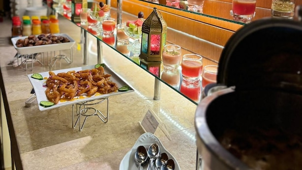 A buffet with various food items and drinks, including fruits, desserts, and a selection of beverages. - Safeer International Hotel (Muscat)