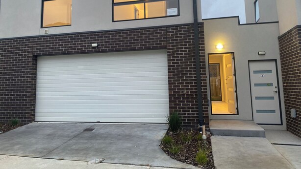 A two-story building with a garage door, a brick facade, and a small entryway with a door marked '31'. - Unfurnished-2 Story 3 Bedroom House- 30min to Melbourne international Airport (South Morang)