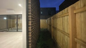A modern building with a glass facade, a brick wall, and a wooden fence. - Unfurnished-2 Story 3 Bedroom House- 30min to Melbourne international Airport (South Morang)