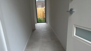 A narrow hallway with grey tiled flooring and white walls. - Unfurnished-2 Story 3 Bedroom House- 30min to Melbourne international Airport (South Morang)