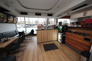 A restaurant with a wooden interior, a counter, and seating area. - Hotel Kleinmünchen  (Linz)