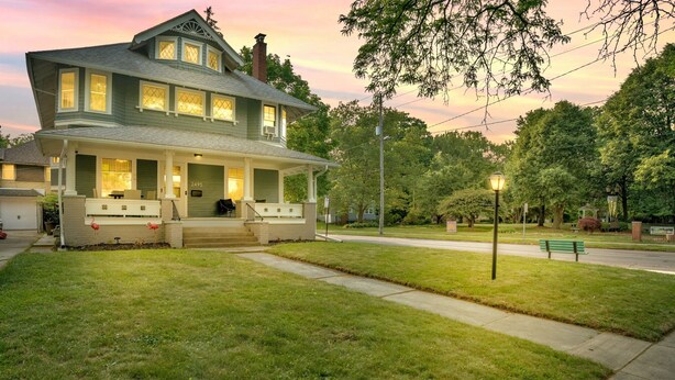 A two-story house with a porch and a well-maintained lawn.