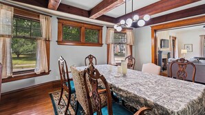 A dining area with a wooden table, chairs, and a chandelier.