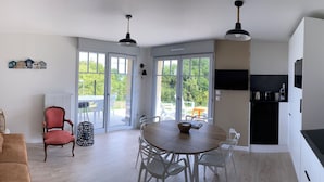 Une cuisine moderne avec un coin repas, un canapé et un fauteuil.