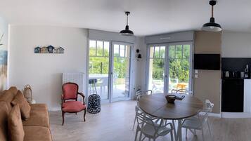 A modern kitchen with a dining area, a sofa, and a chair.