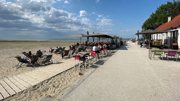 Un café situé en bord de mer, avec une terrasse et vue sur l’océan.