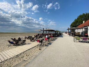Un café situé en bord de mer, avec une terrasse et vue sur l’océan.