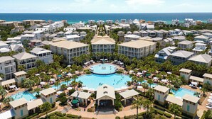 Un resort con varias edificaciones, una piscina central y vista al océano.
