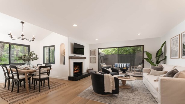 Una sala de estar moderna con chimenea, un comedor y un sofá.