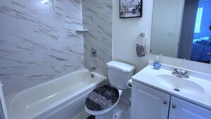 A bathroom with a bathtub, toilet, sink, and a mirror. - Linda Casa peaceful neighborhood  (Aurora)