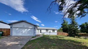 A residential house with a garage, a front yard, and a wooden fence. - Linda Casa peaceful neighborhood  (Aurora)