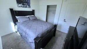 A bedroom with a bed, a wardrobe, a television, and a wall with a 'GUCCI' sign. - Linda Casa peaceful neighborhood  (Aurora)