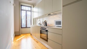 Una cocina moderna con horno integrado, microondas y cafetera.