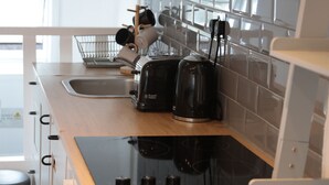 Eine Küche mit Spüle, Toaster und Wasserkocher auf der Arbeitsfläche.
