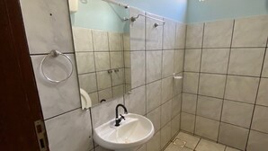 Un bagno piccolo con lavandino, specchio e water.