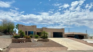 A modern two-story house with a garage, landscaped garden, and a clear sky. - Sante Fe Style pool home (Lake Havasu City)