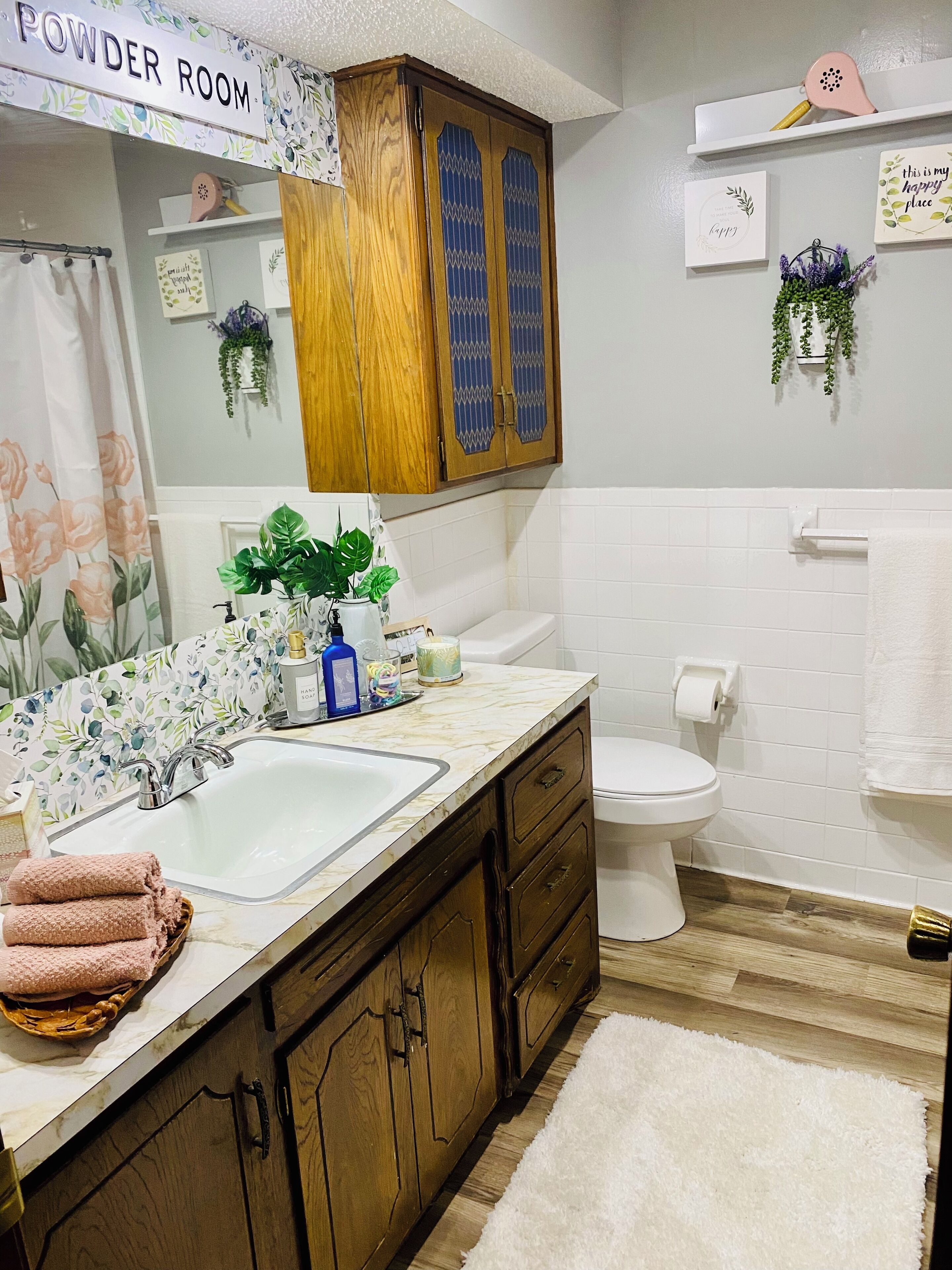 Une salle de bain avec un meuble-lavabo en bois, un évier, des toilettes et un espace douche.