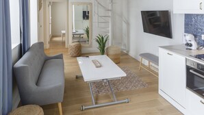 Una sala de estar moderna con sofá, mesa de centro y área de cocina.