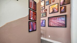 A hallway with a series of framed artworks on the walls. - River Rock Studio w/private courtyard, 20 minutes to Zion (Virgin)
