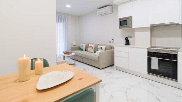 A modern apartment with a kitchen, dining area, and living room. - Apartment 2 bedrooms near Las Canteras beach (Las Palmas de Gran Canaria)