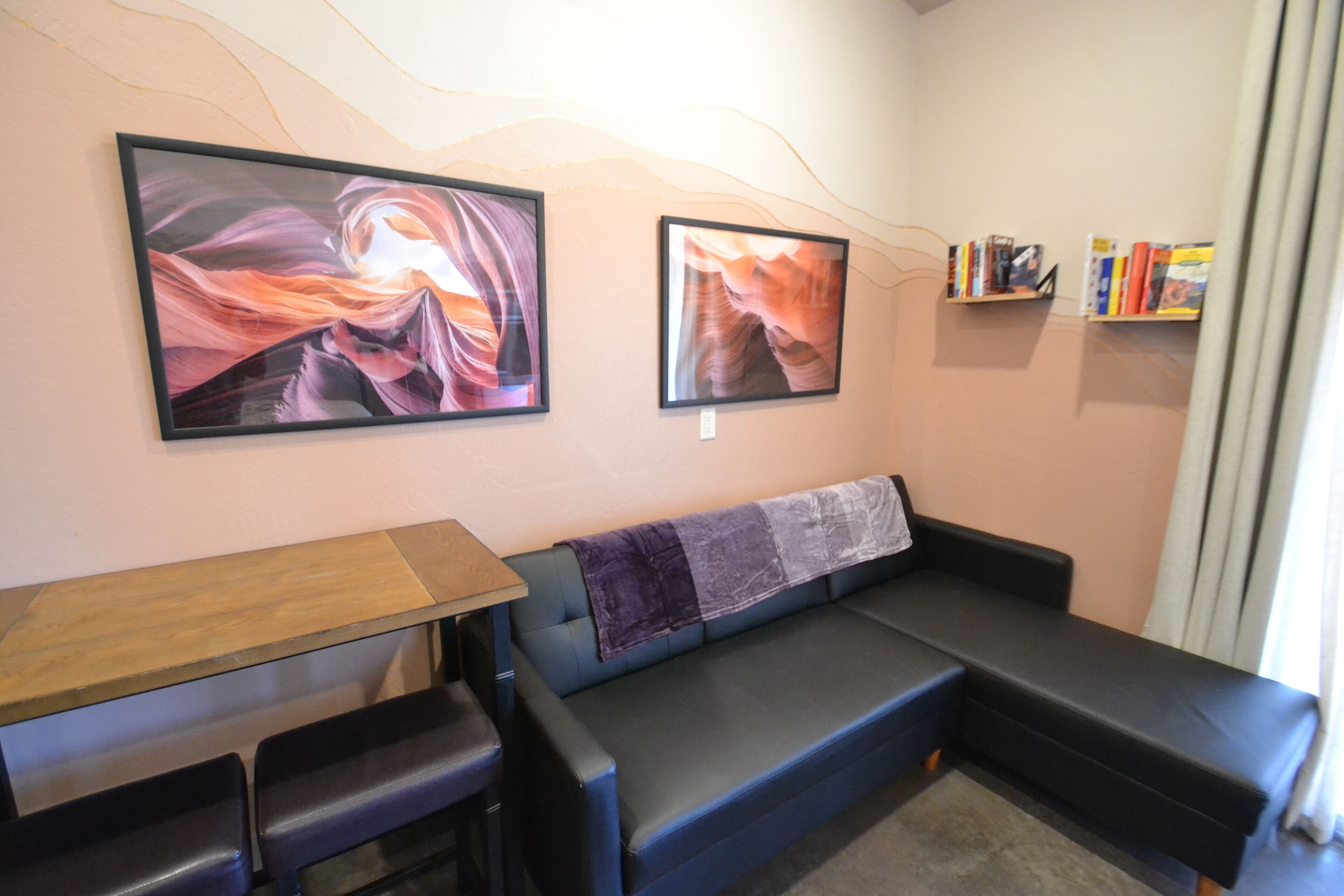 A living room with a sofa, a small table, and two framed pictures on the wall.