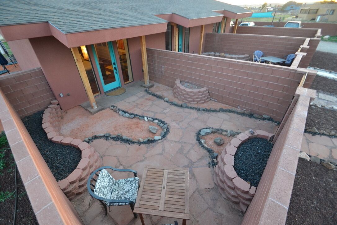 A patio area with a brick wall, a fire pit, and outdoor furniture.