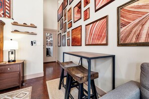 A room with a wooden desk, a chair, a lamp, and a wall adorned with framed artwork. - Sandstone Studio w/Private Courtyard, 20 minutes from Zion (Virgin)