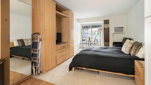 Un dormitorio con cama, armario, escritorio y silla.
