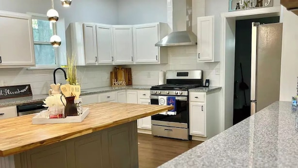 A modern kitchen with white cabinets, a granite countertop, and a central island. - My house your house (Fort Smith)