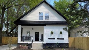 A single-story house with a gabled roof, a front porch, and a small front yard with a garden bed and a mailbox. - My house your house (Fort Smith)