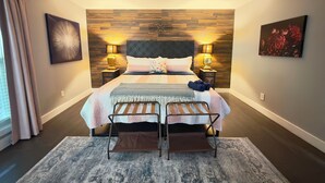 Ein Schlafzimmer mit einem Bett, zwei Nachttischen, einem Deckenventilator und einem großen Wandbild.