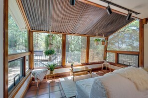 A spacious room with large windows, a wooden ceiling, and a cozy bed with a white furry throw. - Meadow Vista Mountain Escape w/ River Views! (Meadow Vista)