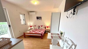 A bedroom with a bed, bedside tables, a desk, and chairs.