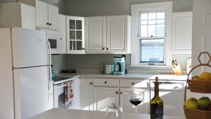 A kitchen with white cabinets, a microwave, a coffee maker, and a window. - House in Quaint Neighborhood near Downtown Milwaukee Pet-Friendly! (Milwaukee)