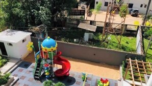 A playground with a slide, climbing structures, and a bumper car area. - Modern Nearby Beach Apartment (Serrekunda)