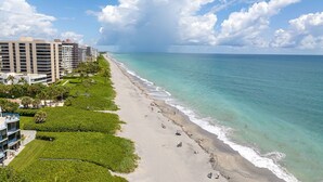 A beachfront hotel with multiple floors, a sandy beach, and a clear view of the ocean. - ON The Beach Juno! 4-Steps to the Beach! (Juno Beach)