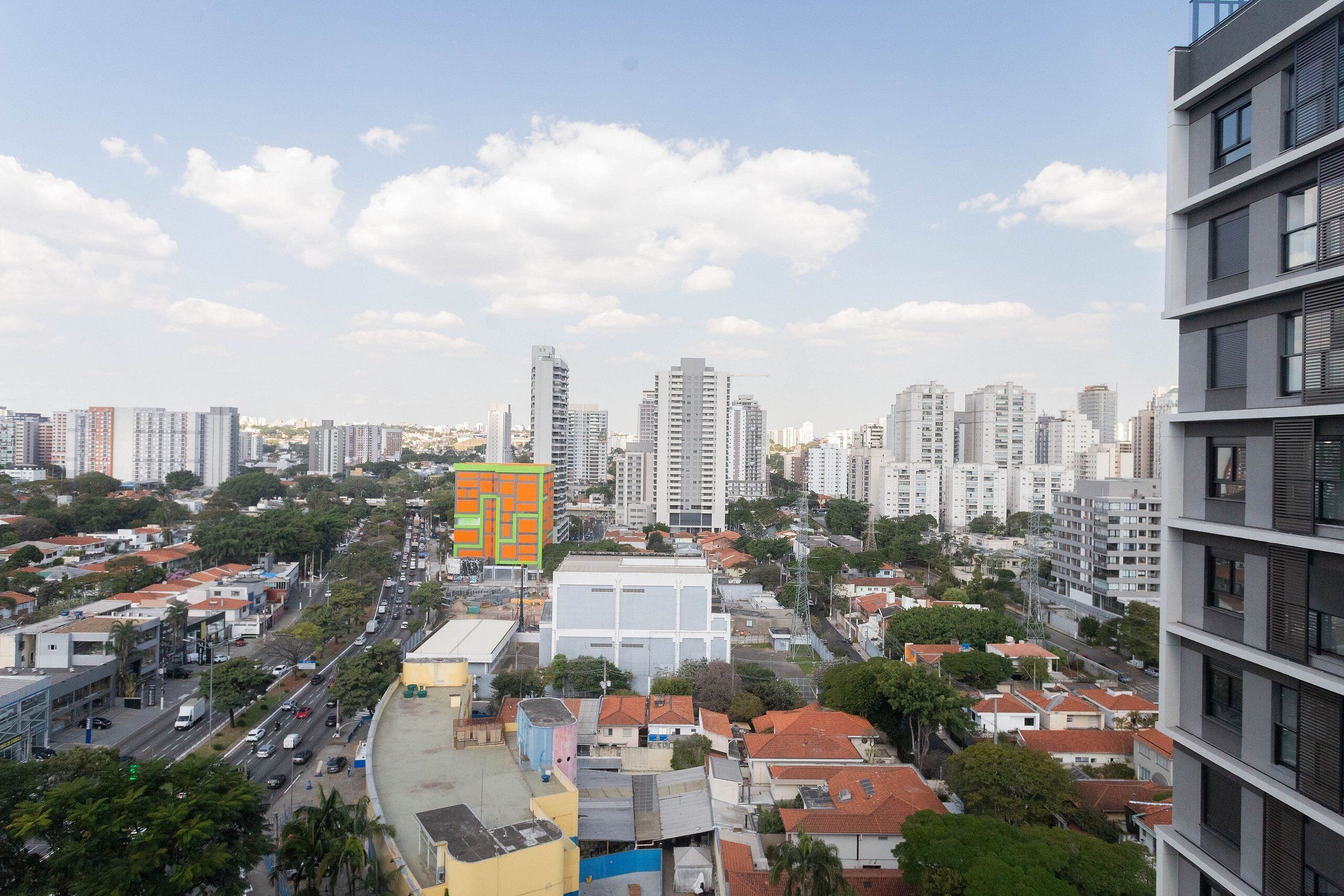 A high-rise building with multiple floors, surrounded by other buildings and greenery.