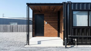 A modern building with a wooden exterior and a black door. - RIVIERA Kujukuri (Kujukuri)